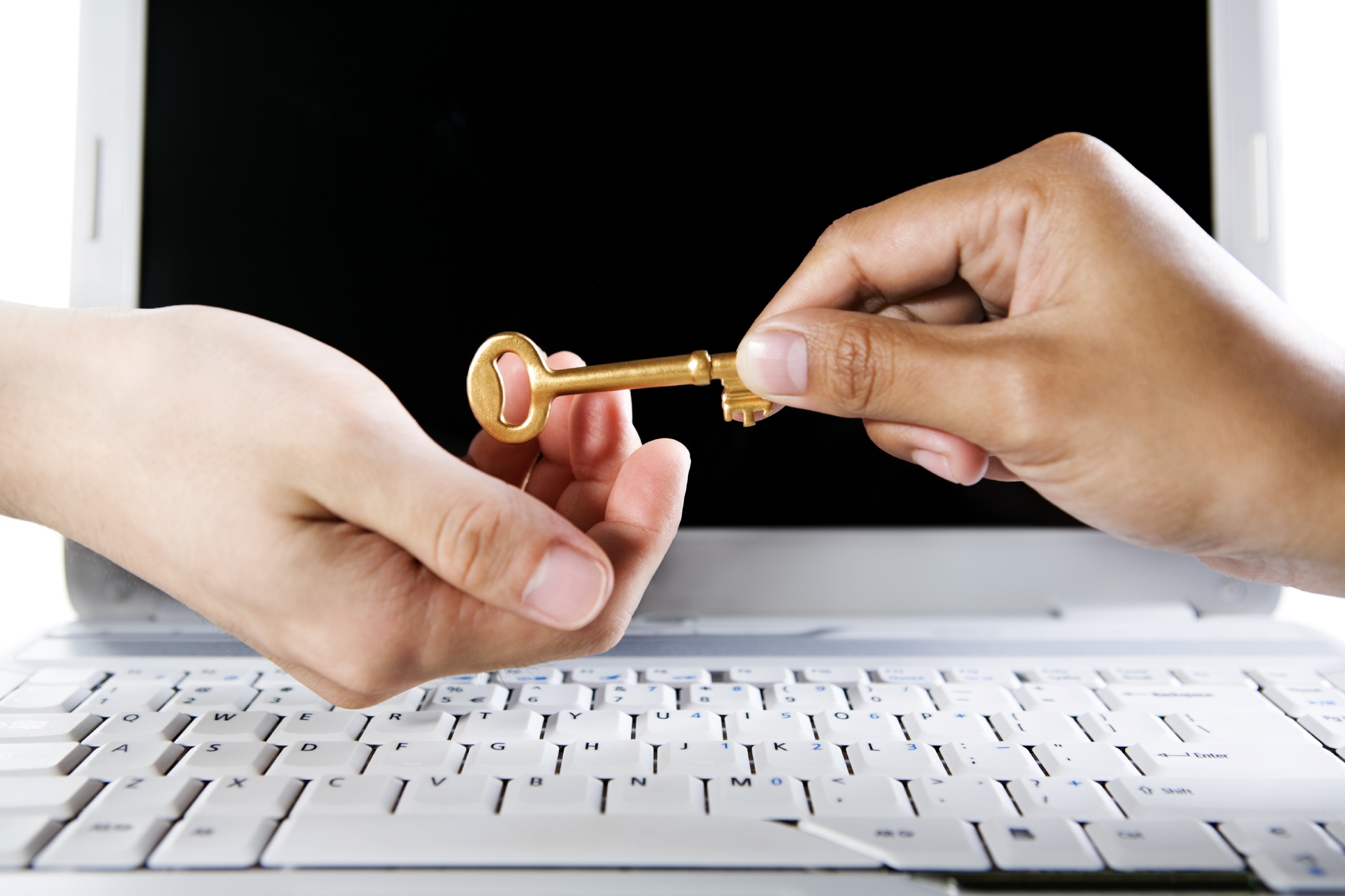 Handing over the golden key, both hands are over the laptop.